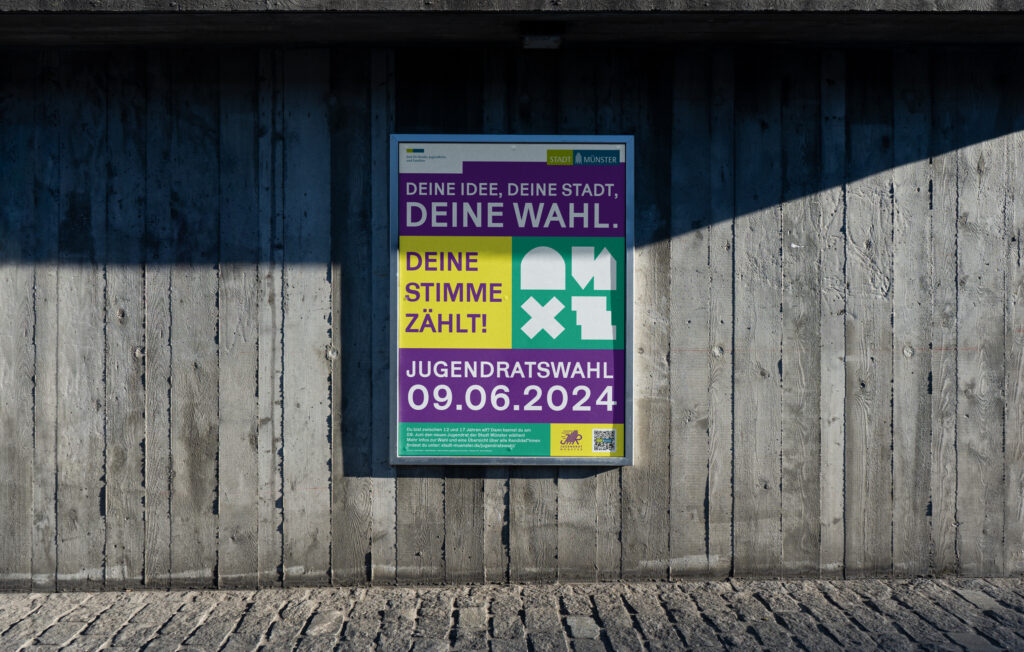 Auf dem Foto ist das Plakat für die Jugendauswahl 2024 in Münster zu sehen. Es besteht aus großer Schrift, knalligen Farben (Lila, Gelb und Grün) und abstrakten Icons.